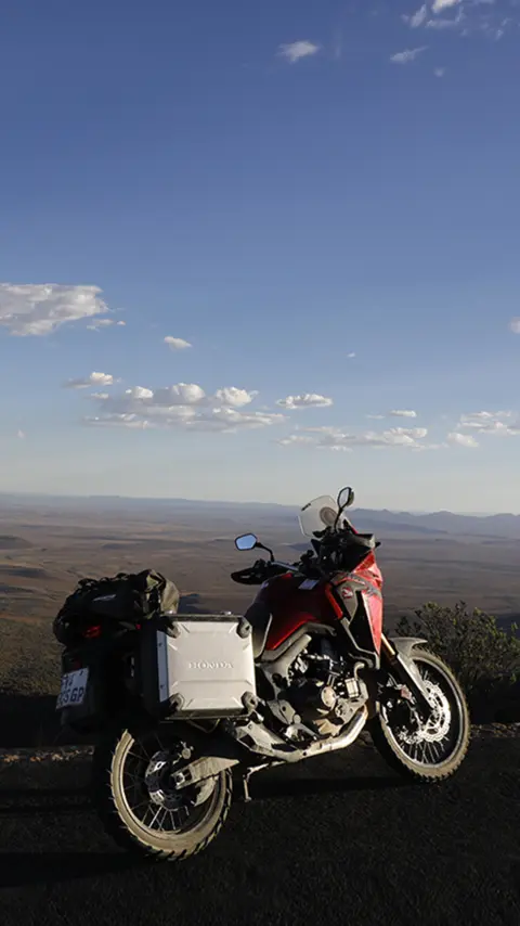 Honda CRF1000L Africa Twin parcheggiata sul ciglio della strada che domina il deserto del Karoo.