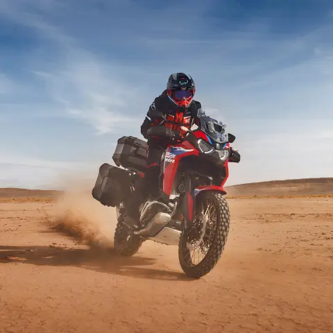 Motociclista su Honda CRF1100 Africa Twin Adventure Sport nel deserto.