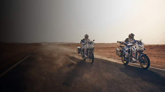 Vista anteriore di tre quarti di CRF1100L Africa Twin Adventure Sports su una strada nel deserto. 