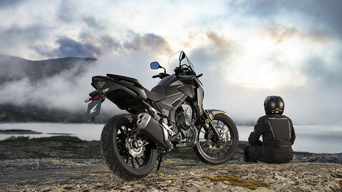 CB500X, vista di 3/4 posteriore destra accanto al pilota seduto, in ambiente montano