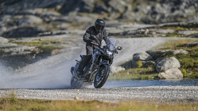 Honda CB500X mentre attraversa un corso d'acqua.