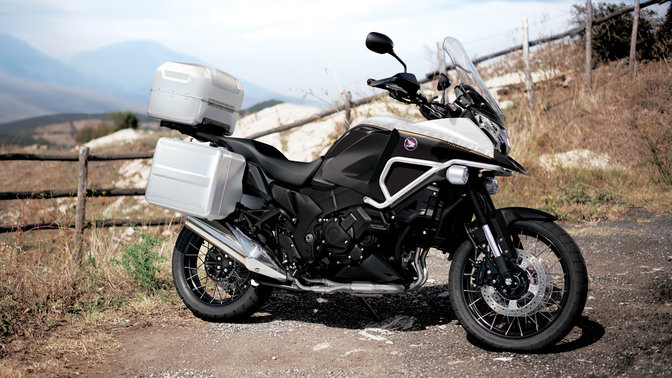 Inquadratura frontale lato destro della Honda Crosstourer grigia. Ambiente rurale.