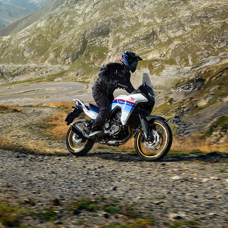 XL750 Transalp su pista sterrata di fronte alle montagne.