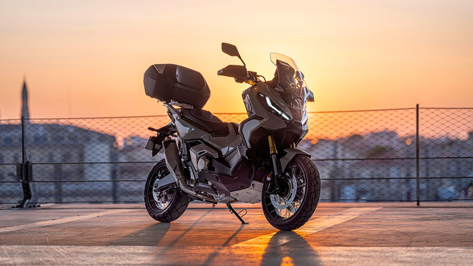 Honda X-ADV, vista anteriore di tre quarti destra, parcheggiata in un parcheggio, al tramonto