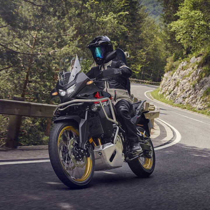 Modello alla guida della XL750 Transalp in un luogo di montagna.