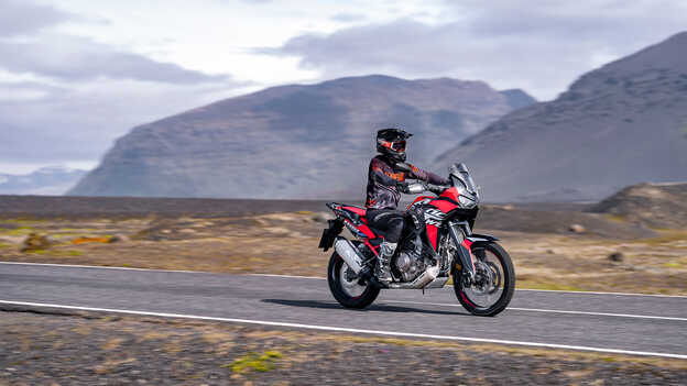 Vista anteriore di tre quarti di Africa Twin con pilota su strada