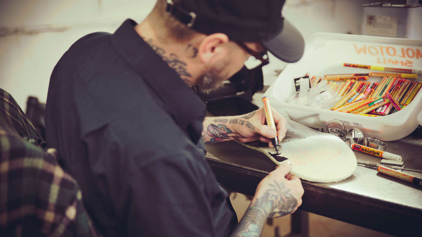 Dan Gold disegna su uno skateboard.