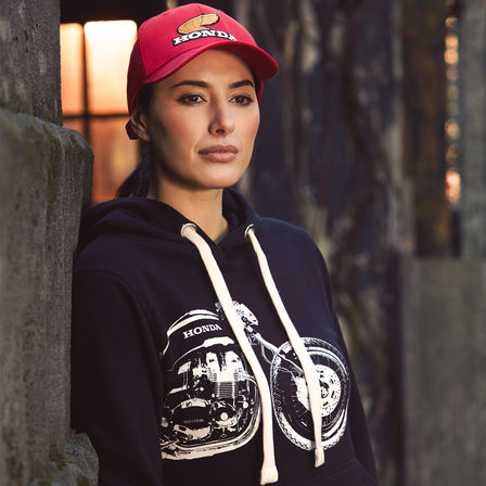 Donna che indossa felpa con cappuccio e cappellino Honda vintage. 