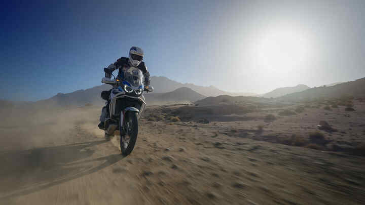 Pilota Honda Adventure Roads in Marocco su terreno polveroso.