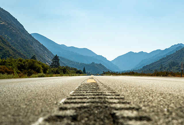 Strada asfaltata aperta che porta verso le montagne