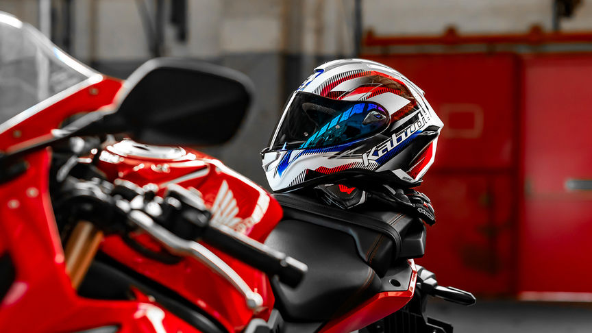 Casco Honda Kabuto, Aeroblade V, Go White Blue Red, CBR650, lato sinistro, appoggiato sul serbatoio di una motocicletta