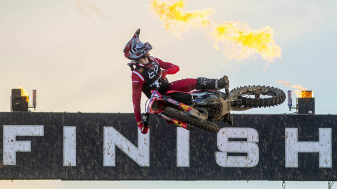Pilota Honda del Campionato Mondiale di Motocross durante un salto al traguardo.