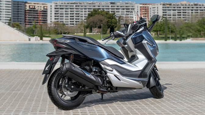Vista laterale Honda Forza 300 in città.