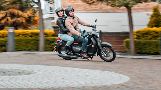 Honda Monkey sul cavalletto laterale in strada con pilota