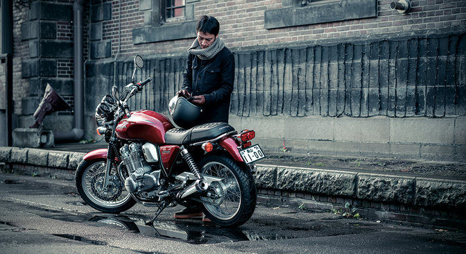 Vista posteriore a tre quarti della Honda CB1100EX e del motociclista.