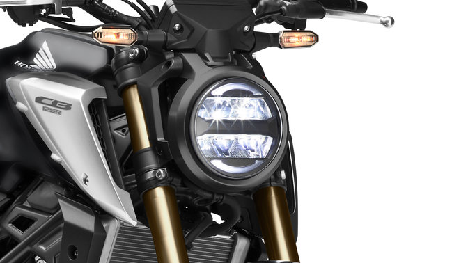 Honda CB125R, vista anteriore di tre quarti destra, primo piano sulle luci, scatto in studio, moto nera