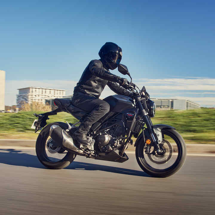 Vista laterale della Honda CB300R guidata lungo una strada.