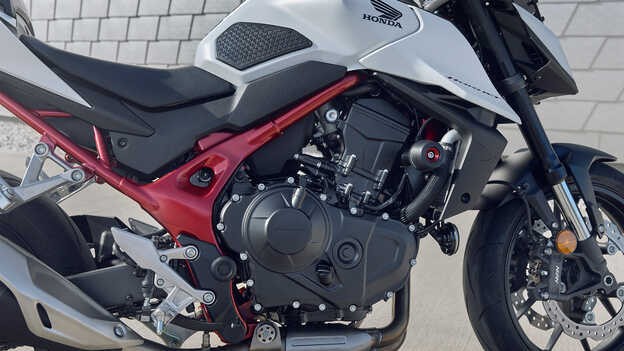 Honda CB750 Hornet con uomo appoggiato all'edificio.