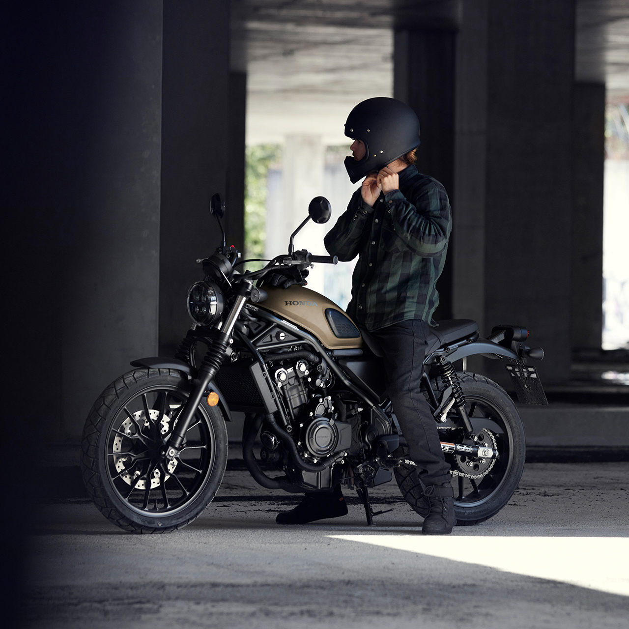 Rider che sistema il casco mentre è seduto sulla moto Honda CL500.