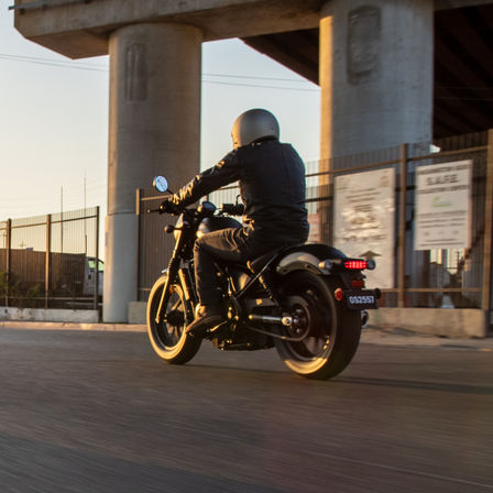 Inquadratura di tre quarti posteriore della Honda CMX500 Rebel guidata su strada.