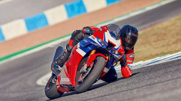 Scatto dinamico della Honda CBR1000RR-R Fireblade in pista con il pilota che accelera in uscita di curva.