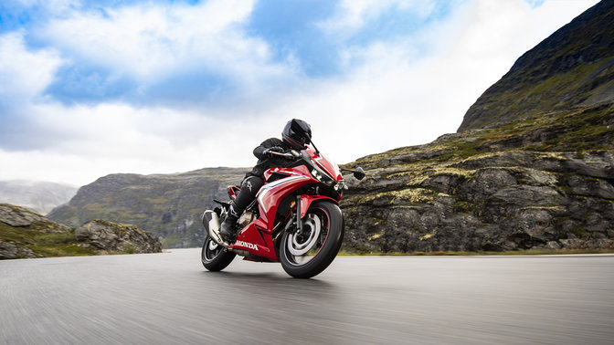 CBR500R, vista di 3/4 frontale destra, in azione con pilota su una strada di montagna