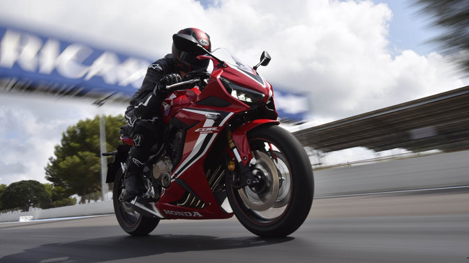 CBR650R, vista di tre quarti frontale destra, in velocità su pista con guidatore