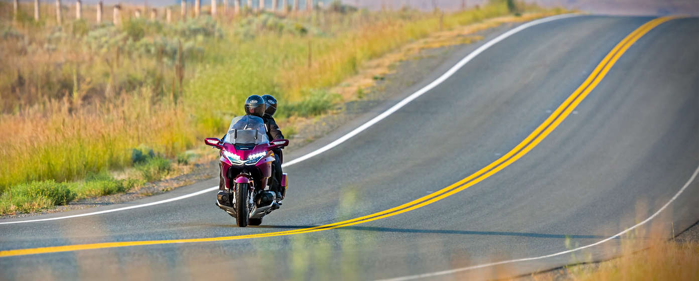 Pilota e passeggero sul sellino posteriore su una Honda Goldwing.
