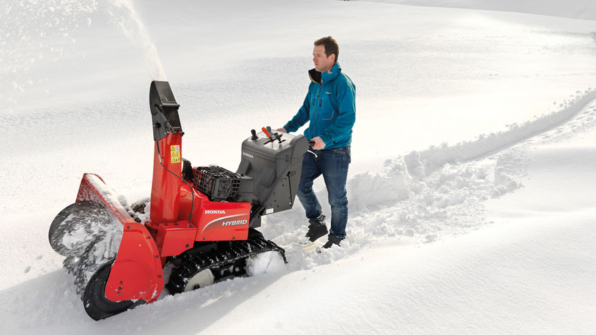 Spazzaneve ibrido utilizzato da un operatore, sulla neve.