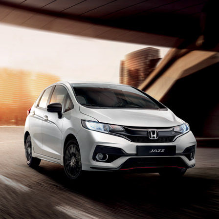 Honda Jazz su strada con città sullo sfondo