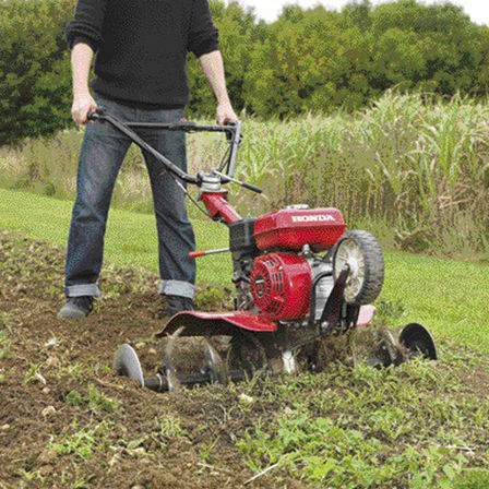 Motozappa compatta, utilizzata da un operatore, luogo di utilizzo: giardino.