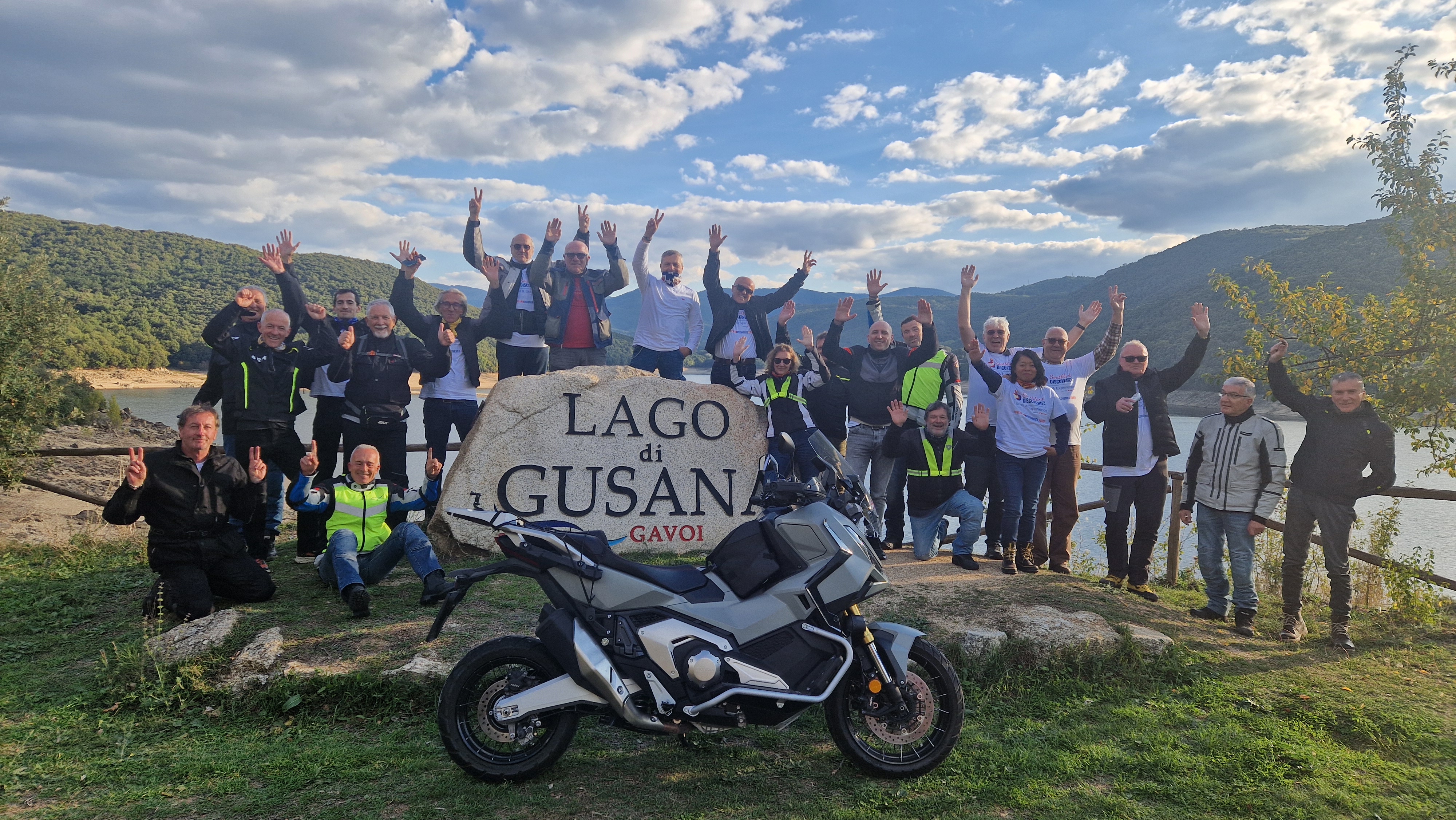 Un'immagine divisa che mostra una strada costiera panoramica, una moto Honda Africa Twin su una strada di montagna e un villaggio costiero sullo sfondo.