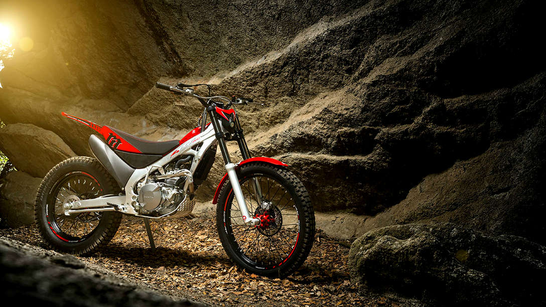 Front-threequarter view of CRF150 with rider in dirt race location.